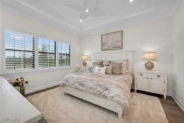 bedroom with a raised ceiling, ornamental molding, dark wood-style floors, recessed lighting, and baseboards