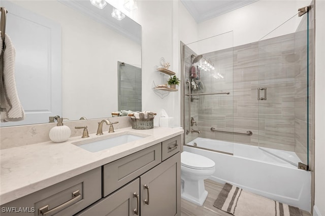 full bath featuring shower / bath combination with glass door, toilet, vanity, and ornamental molding