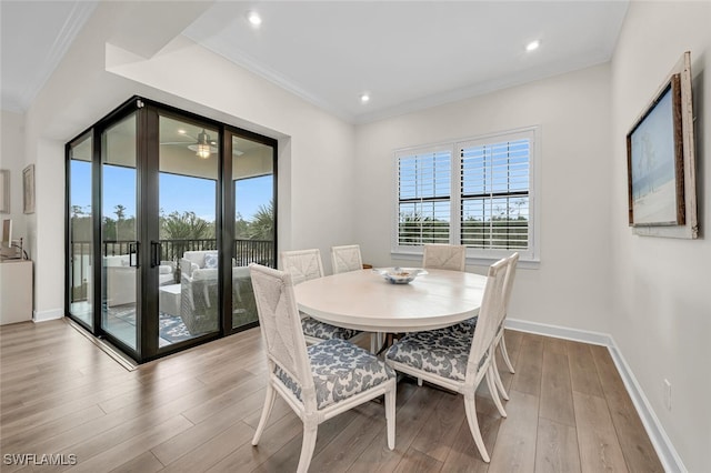 dining room featuring crown molding, wood finished floors, baseboards, and a healthy amount of sunlight