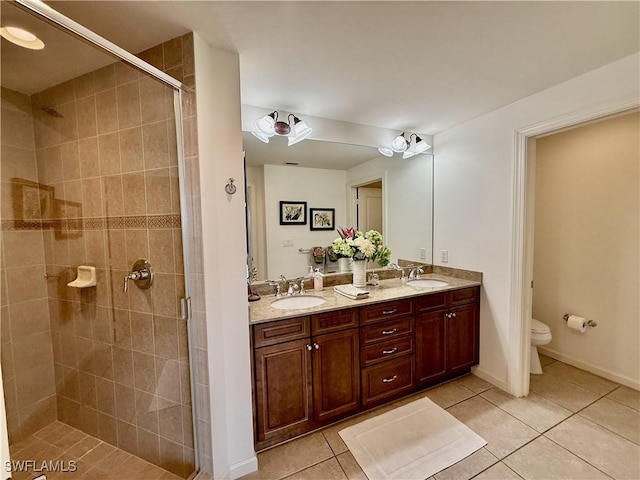 bathroom featuring toilet, a sink, tile patterned floors, double vanity, and a stall shower