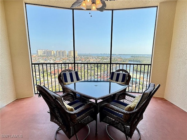 sunroom featuring a city view and ceiling fan