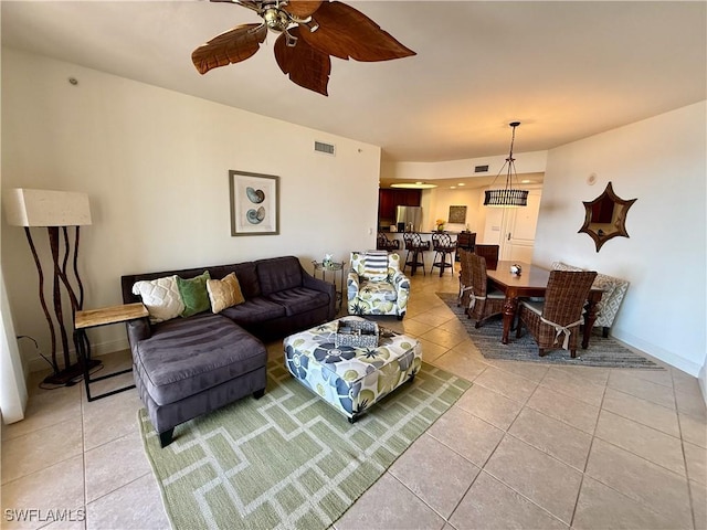 living room featuring light tile patterned floors, baseboards, visible vents, and a ceiling fan