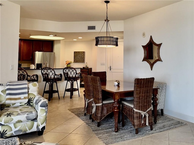 dining space with light tile patterned floors, visible vents, and baseboards