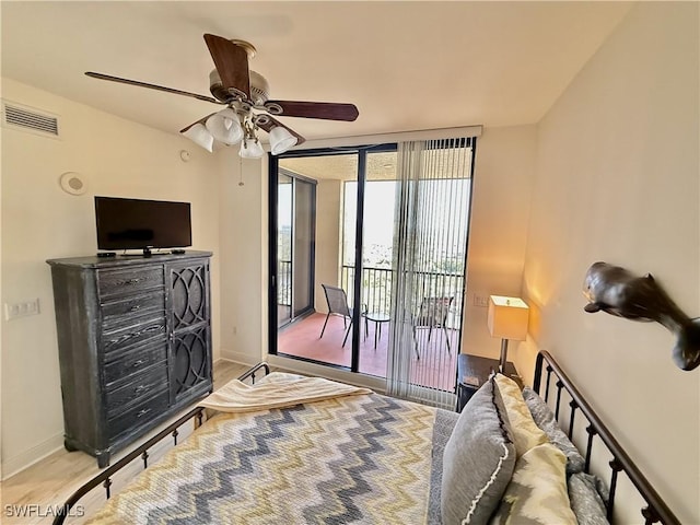 bedroom featuring access to exterior, visible vents, baseboards, and wood finished floors