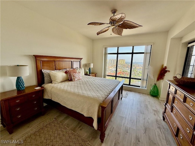 bedroom featuring ceiling fan, baseboards, and wood finished floors