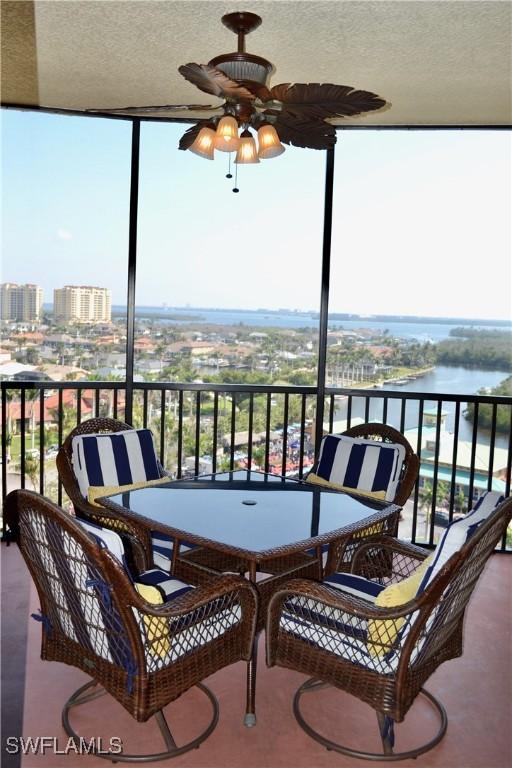 balcony with a water view and ceiling fan