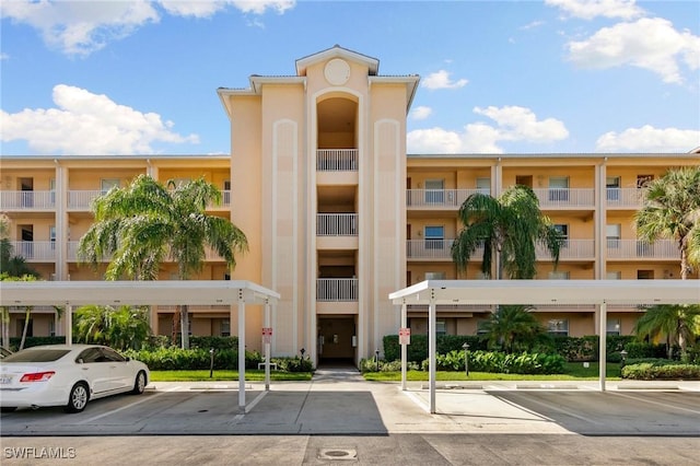 view of property featuring covered and uncovered parking