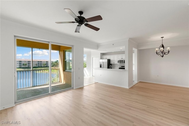 unfurnished living room featuring ceiling fan with notable chandelier, baseboards, light wood finished floors, and ornamental molding