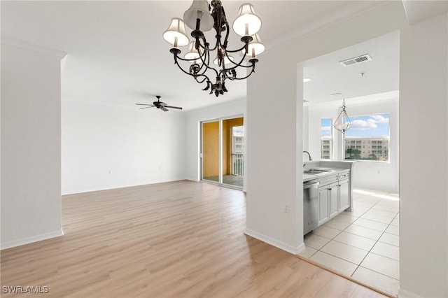 interior space featuring visible vents, ornamental molding, a sink, decorative light fixtures, and stainless steel dishwasher