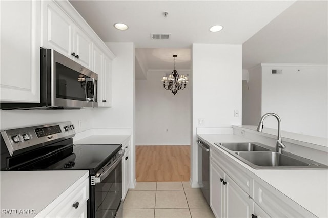 kitchen with visible vents, a sink, ornamental molding, stainless steel appliances, and white cabinets