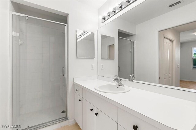 bathroom with visible vents, a stall shower, and vanity