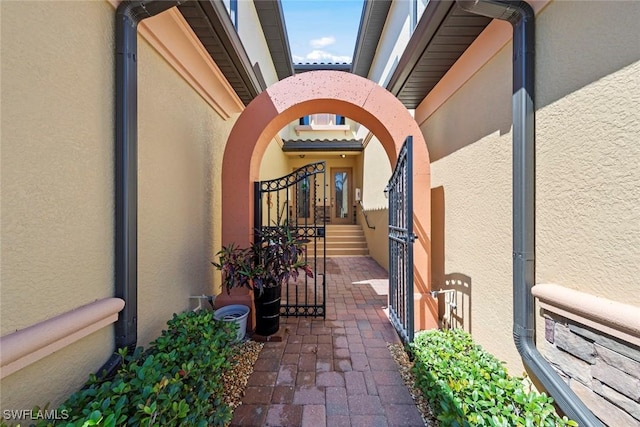 exterior space with stucco siding and a gate