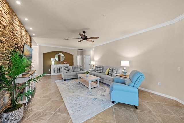 living room featuring light tile patterned flooring, baseboards, a ceiling fan, and ornamental molding