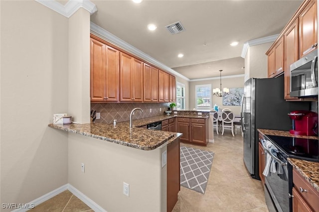 kitchen featuring tasteful backsplash, appliances with stainless steel finishes, a peninsula, crown molding, and an inviting chandelier