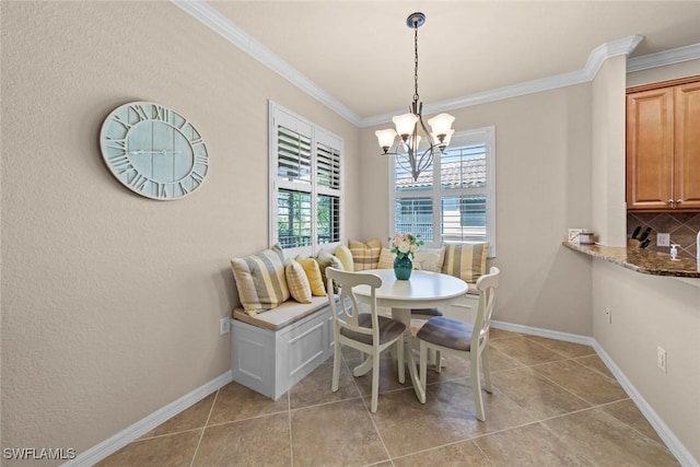 dining area with light tile patterned floors, baseboards, a notable chandelier, and crown molding