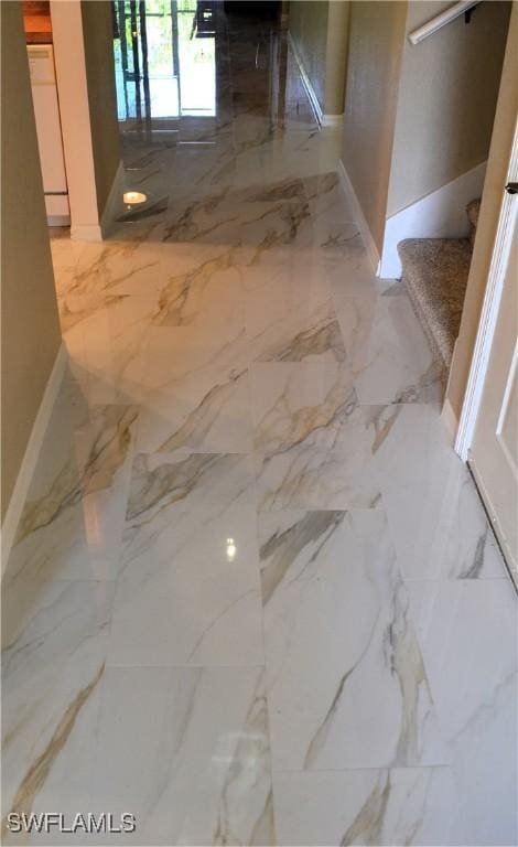 hall featuring baseboards, marble finish floor, and stairs