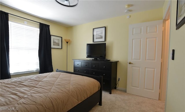 bedroom featuring light carpet and multiple windows