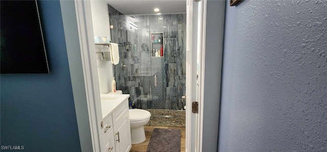 full bathroom featuring toilet, a stall shower, and vanity