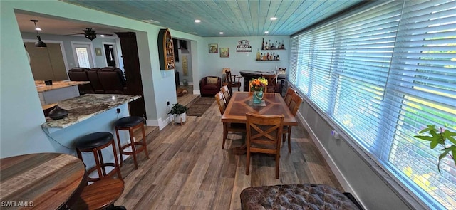 dining area featuring recessed lighting, wood finished floors, a ceiling fan, baseboards, and a dry bar