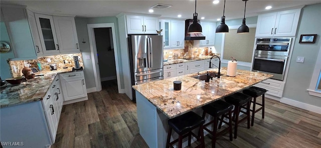 kitchen featuring stainless steel appliances, a sink, visible vents, and white cabinetry