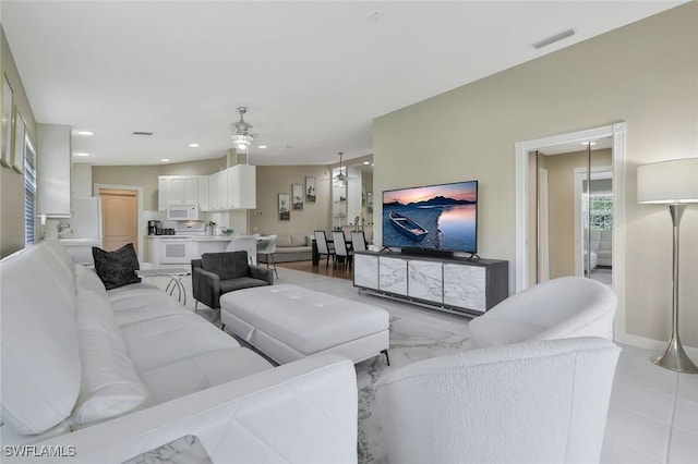 living room with recessed lighting, visible vents, ceiling fan, and baseboards