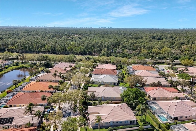 drone / aerial view with a water view, a residential view, and a view of trees