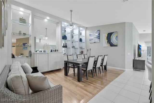 dining space with light wood-style floors, ceiling fan, and baseboards