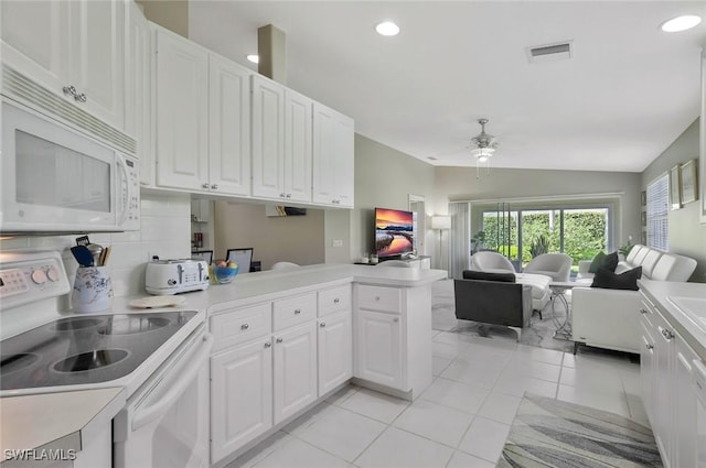 kitchen featuring white appliances, visible vents, white cabinets, open floor plan, and a peninsula