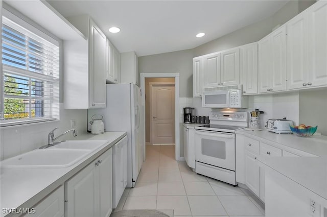 kitchen featuring light countertops, white appliances, white cabinets, and a sink