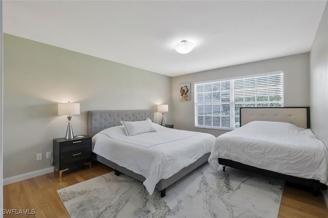 bedroom with wood finished floors and baseboards