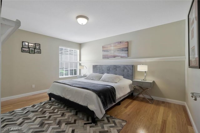 bedroom featuring baseboards and wood finished floors