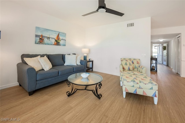 living area featuring visible vents, ceiling fan, baseboards, and wood finished floors