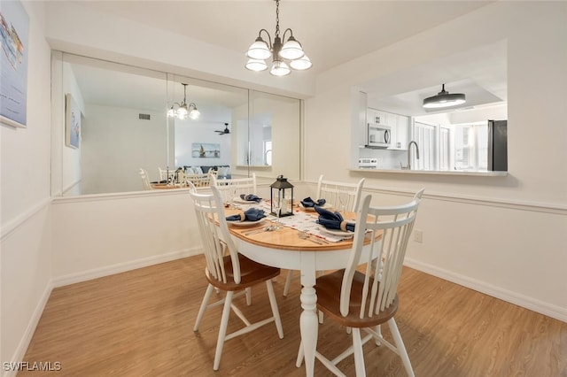 dining space featuring baseboards, visible vents, and light wood finished floors