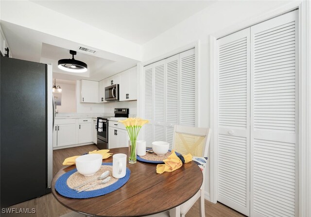 dining room with light wood finished floors and visible vents