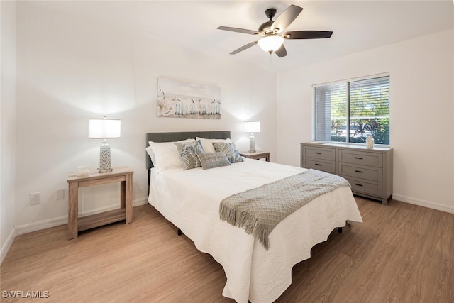 bedroom featuring light wood finished floors, a ceiling fan, and baseboards