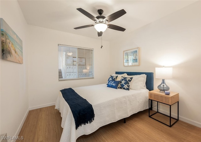 bedroom with ceiling fan, baseboards, and wood finished floors