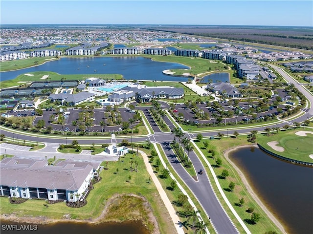 drone / aerial view featuring a water view, view of golf course, and a residential view