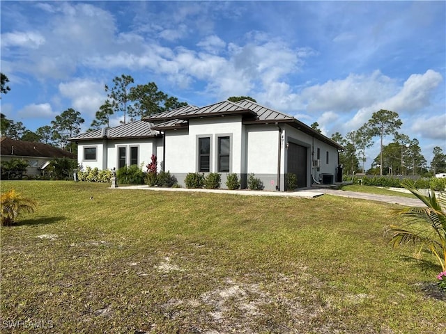 prairie-style home with concrete driveway, a front yard, a standing seam roof, metal roof, and a garage