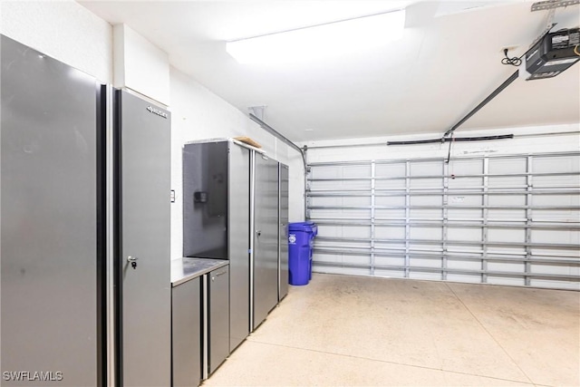 garage with a garage door opener and freestanding refrigerator