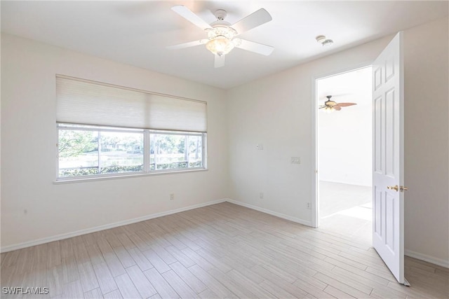 unfurnished room featuring baseboards, light wood-style floors, and a ceiling fan