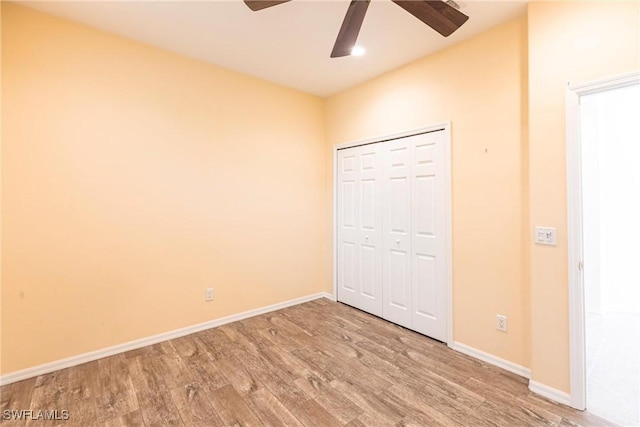 unfurnished bedroom with a closet, a ceiling fan, baseboards, and wood finished floors