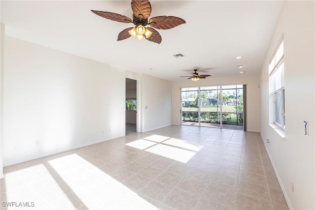 spare room with a ceiling fan, light tile patterned flooring, baseboards, and visible vents