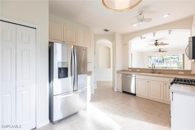 kitchen featuring visible vents, a sink, arched walkways, appliances with stainless steel finishes, and light countertops