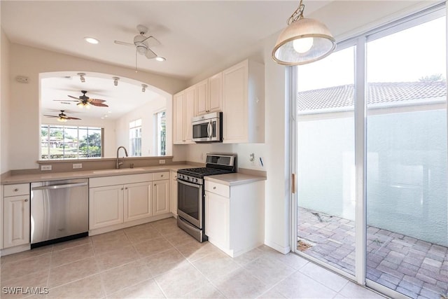 kitchen with a ceiling fan, recessed lighting, arched walkways, a sink, and appliances with stainless steel finishes