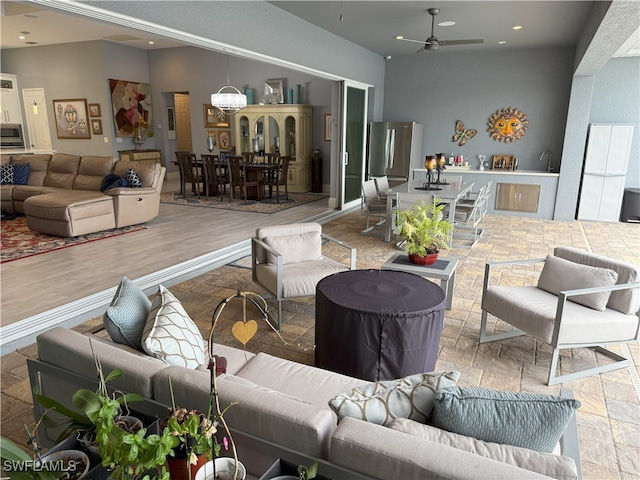 living room featuring ceiling fan with notable chandelier and recessed lighting