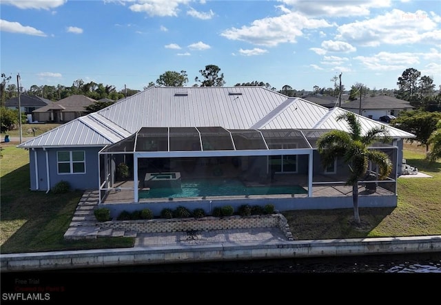 back of house with metal roof, a lanai, a yard, an outdoor pool, and a patio area