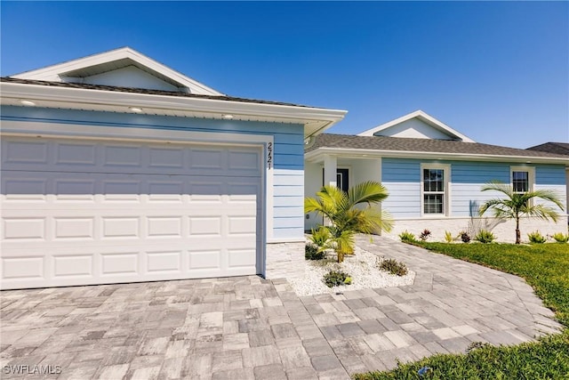 ranch-style house with decorative driveway and an attached garage