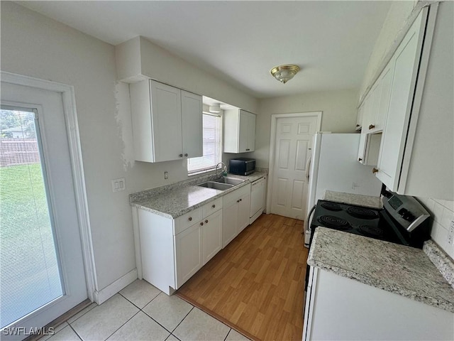 kitchen with stainless steel range with electric stovetop, white cabinets, a sink, and light countertops