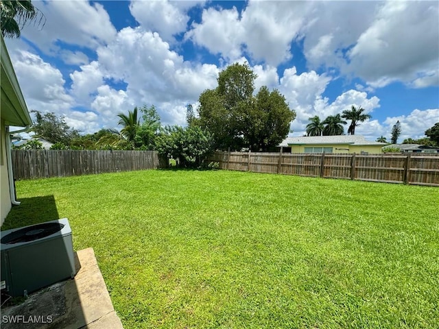 view of yard with central air condition unit and a fenced backyard