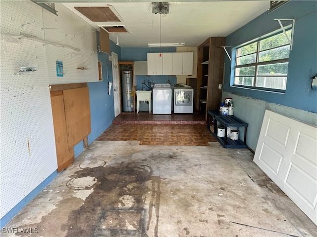 kitchen with white cabinets, electric water heater, concrete floors, separate washer and dryer, and a sink